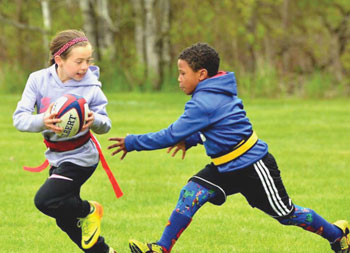 Boy and girl playing rugby